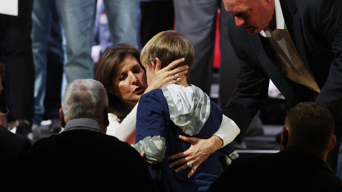 U.S. Presidential candidate Nikki Haley consoles a child who collapsed on stage at her campaign rally Friday in Indian Land, S.C. as her security detail stands by. The boy is the grandson of U.S. Congressman Ralph Norman. Haley told the crowd the boy was hot but that he was being taken care of.