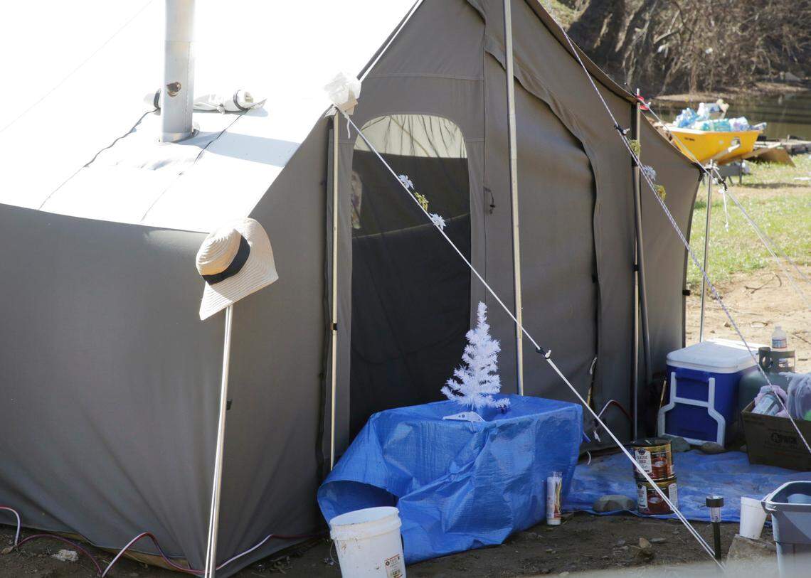 A tent with a Christmas tree by it’s door sits alongside the Swannanoa River the last week in November in Swannanoa, N.C.