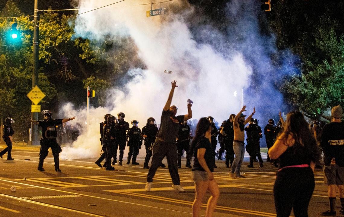 A protester tries to catch a water bottle being thrown at police after insisting on keeping it a peaceful protest in front of the Charlotte Mecklenburg Police Headquarters In Charlotte, NC on Saturday, May 30, 2020.