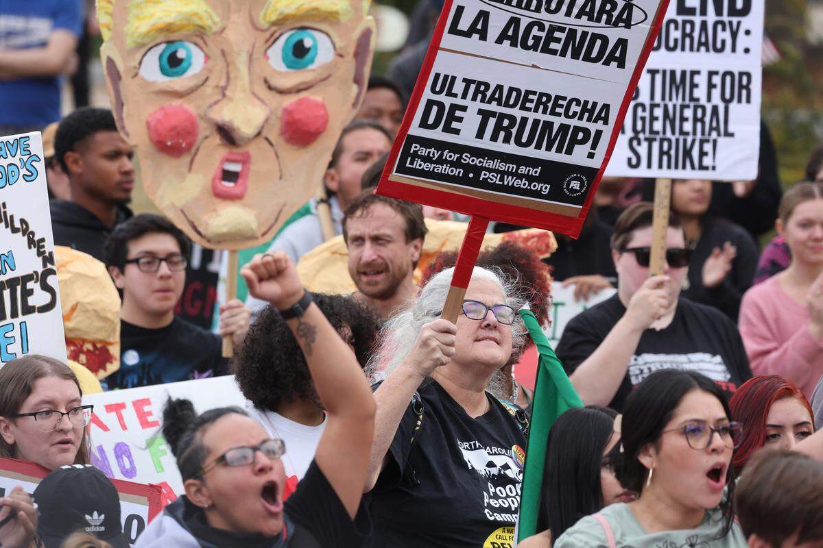 Protesters yell and hold signs Saturday, Nov. 15, 2025 during the No Border Patrol protest in uptown Charlotte.