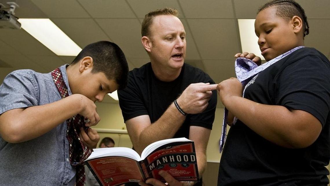 From left, Joan Baez, 13, checks his tie as Jonathan Catherman, founder and author, helps Jesse Hill, 12 with his tie during the Men in the Making Club meeting at Mooresville Middle School on Oct. 19.