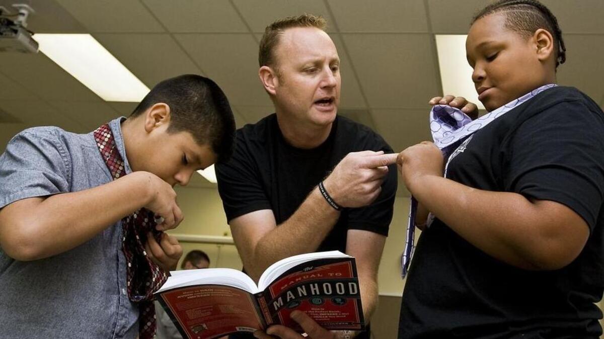 From left, Joan Baez, 13, checks his tie as Jonathan Catherman, founder and author, helps Jesse Hill, 12 with his tie during the Men in the Making Club meeting at Mooresville Middle School on Oct. 19.