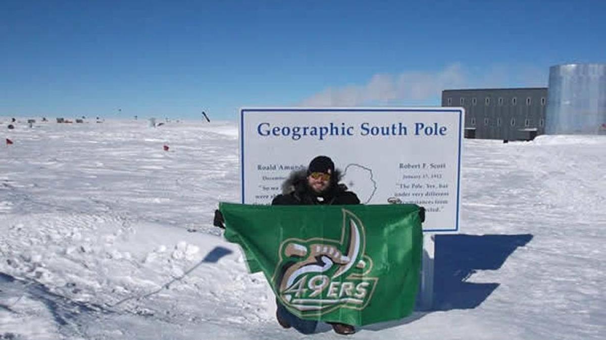UNCC alumnus Justin Marsh flies the 49ers flag at the South Pole.