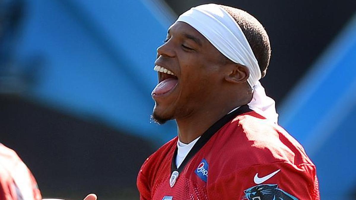 Carolina Panthers quarterback Cam Newton jokes while warming up during the team's organized team activities practice on Tuesday, May 24, 2016.