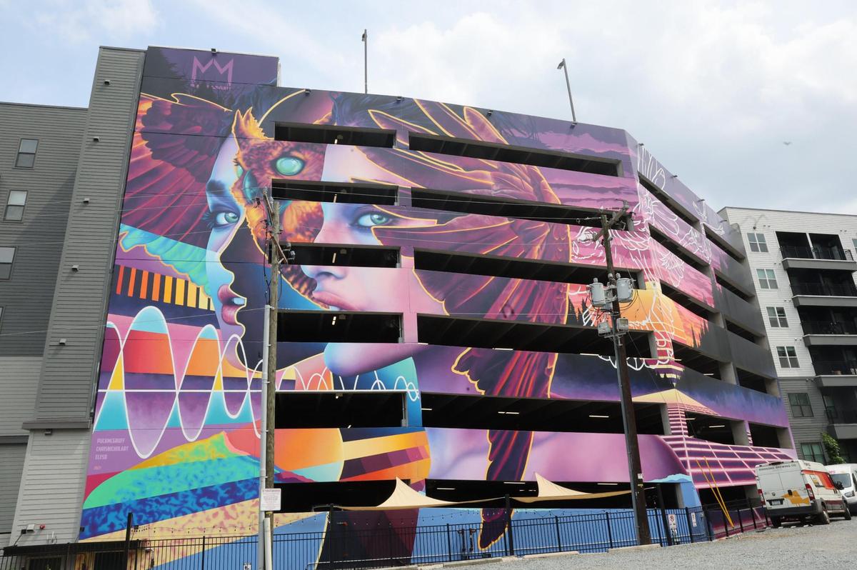 Artists painted a large mural on the parking deck of a large apartment in Optimist Park