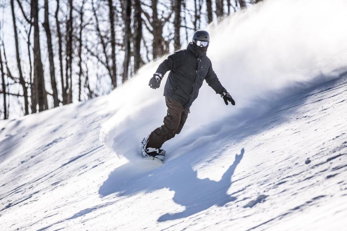 A snowboarder making turns on Upper Flying Mile run at Sugar Mountain ski resort near Banner Elk.