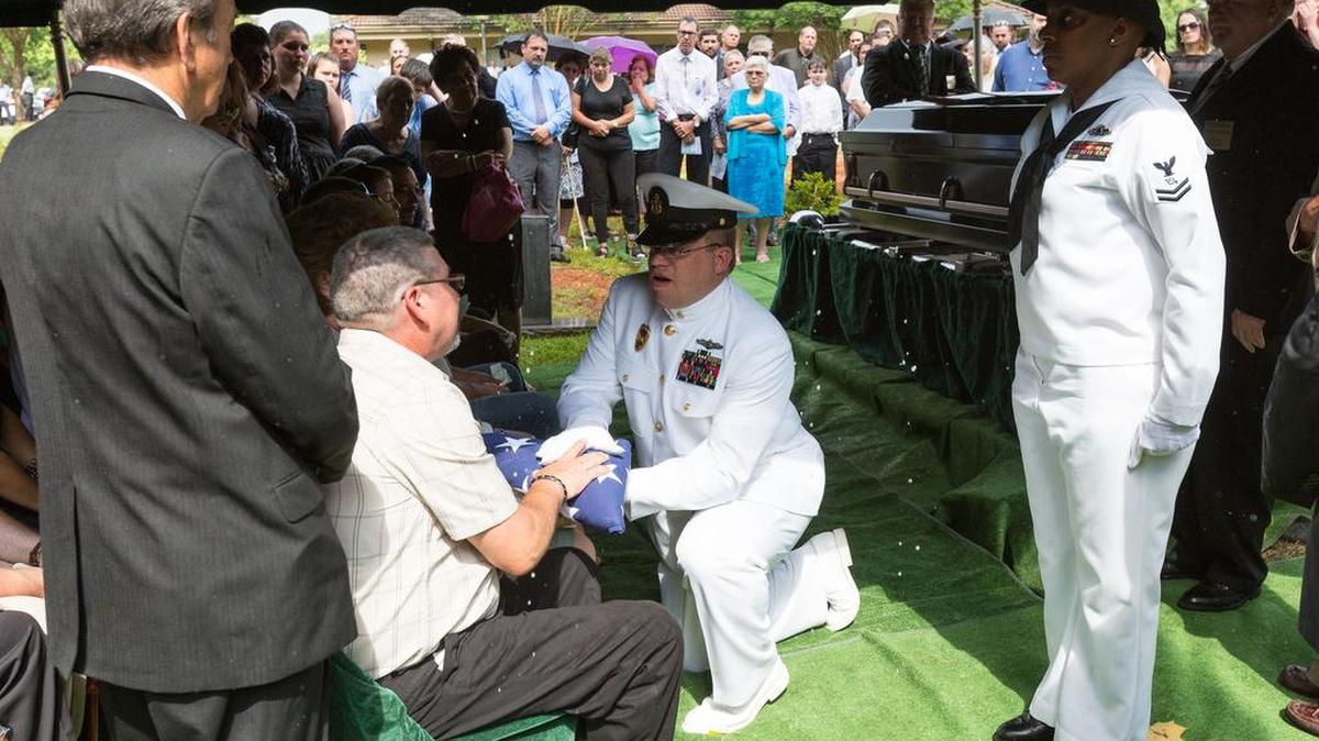 Chris Blue receives the flag from his father’s casket as former Catawba Nation Chief Gilbert Blue is laid to rest Wednesday.