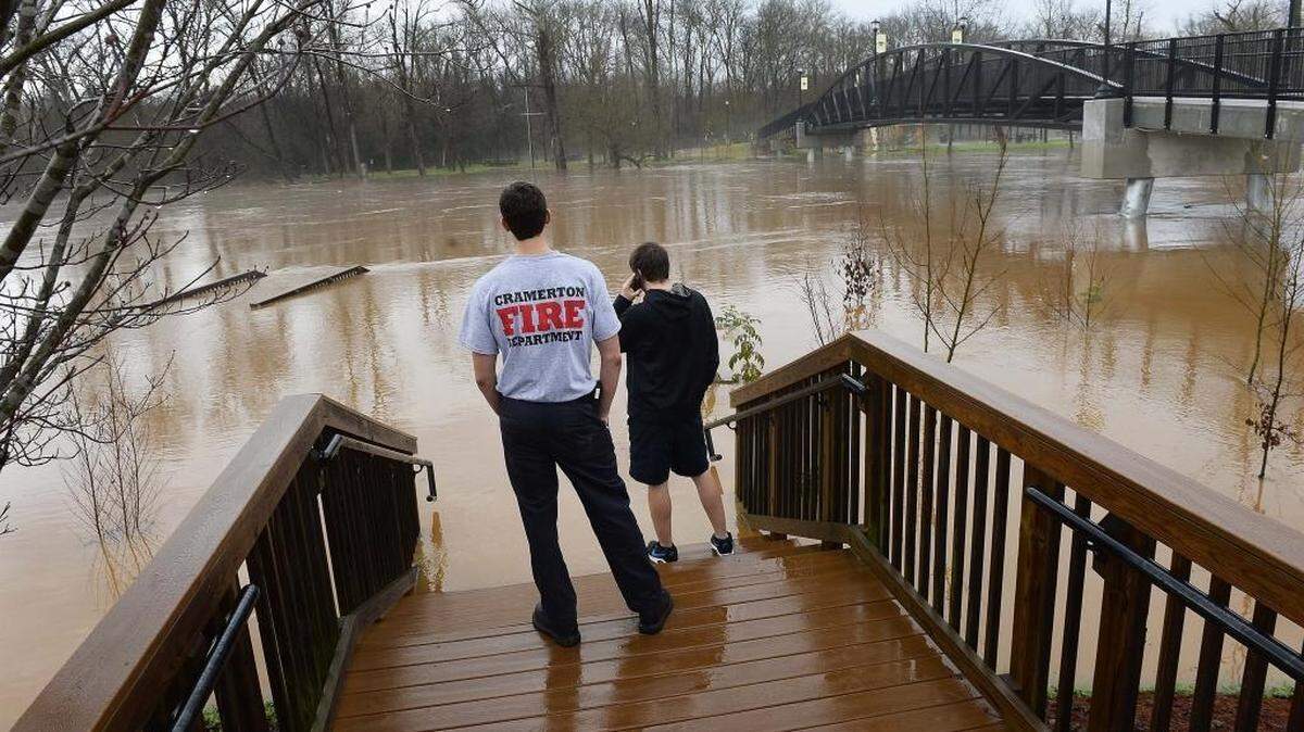 Two Cramerton fire department volunteer fireman keep an eye on the South Fork River as it swells from heavy rains closing Goat Island Park in Cramerton on Dec. 30, 2015.