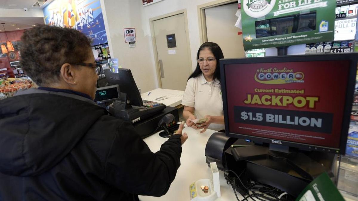Denise Shropshire, left, receives her Powerball ticket from Jyoti Mehta, right, manager of the Highland Creek BP station in Charlotte, on Tuesday, January 12, 2016. On Tuesday afternoon the Powerball jackpot rose to an estimated $1.5 billion.