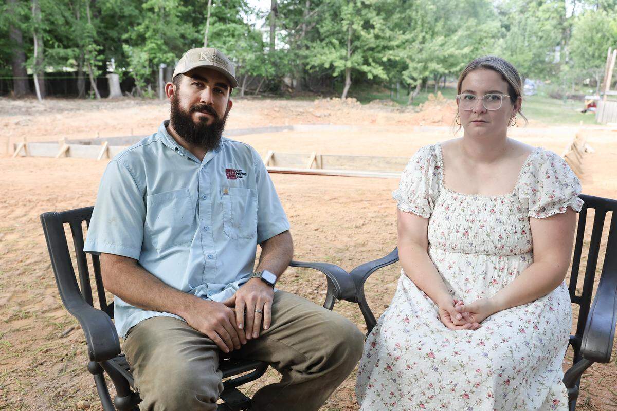 Colby and Mary-Kate Benfield sit near the frame of what was supposed to be a future home on their Fort Mill land on May 11.