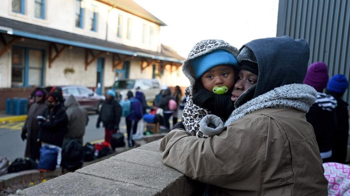 Jedida Blaise, right, huddles up with Nivayah Robinson in the cold as people line up to get food and shelter on Dec. 28 at Urban Ministry Center.