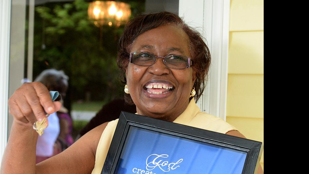 
Betty Patterson of Huntersville celebrates and holds up the keys to her new home after receiving them in a ceremony Sunday. Her home burned in 2012 due to an electrical issue. Huntersville firefighters and community and church volunteers raised about $60,000 for the new home, which is on the site of her former home in the 7200 block of Hambright Road.. Patterson’s homeowner’s insurance was canceled before the fire, Huntersville Fire Department spokesman Bill Suthard said. She was left with nothing, he said. Volunteers formed Build Betty A House, a nonprofit that raised about $60,000 to build Patterson a new home. Habitat For Humanity offered the design work and some technical assistance for free. Since Patterson owned her home, she didn’t qualify for a Habitat home. The Huntersville community and many local churches rallied behind her and through fund raising efforts and hard work were able to build her a brand new home, Suthard said.
