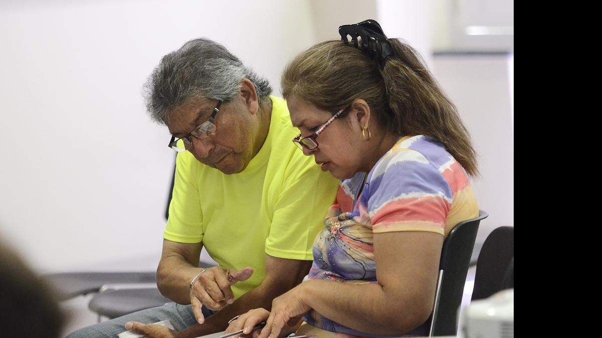
Daniel Arana, who is already a U.S. citizen, helps his wife, Rocia Arana, during immigration class Saturday at the Charlotte Museum of History. 
