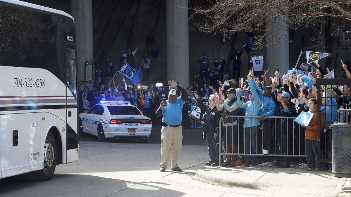 Carolina Panthers fans roar as a bus carrying Panthers players lead by a police escort at the main gate outside Bank of America Stadium on January 31, 2016.