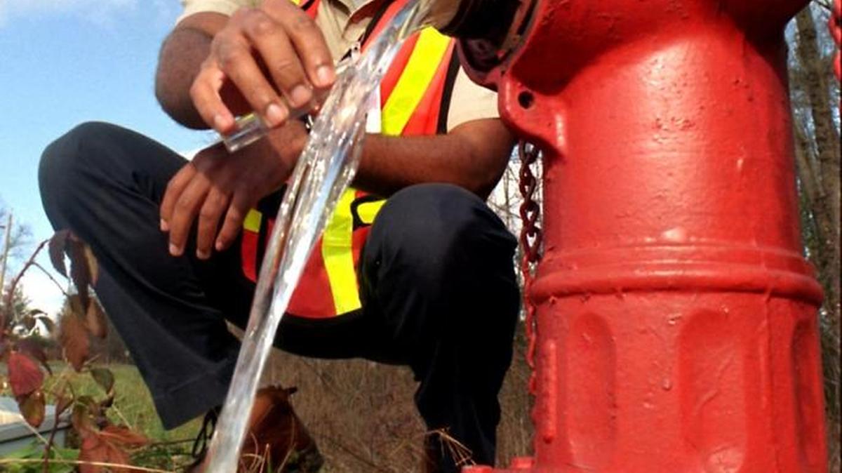 
A lab technician takes a water sample while flushing a hydrant in Gastonia in this file photo.
