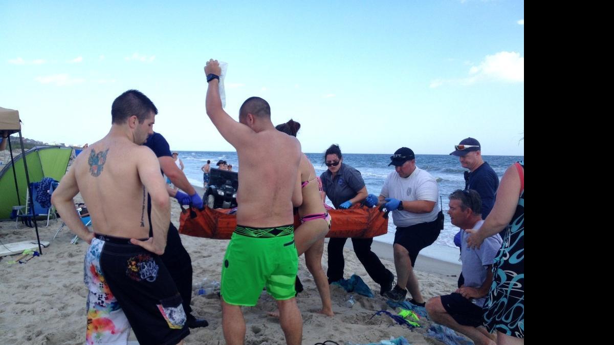
FILE - In this June 14, 2015, file photo, emergency responders assist a teenage girl at the scene of a shark attack in Oak Island, N.C. Officials say a 17-year-old boy is the latest victim of a shark attack off North Carolina's coast, Saturday, June 27, 2015, the second attack in as many days and the sixth attack in the past two weeks. (Steve Bouser/The Pilot, Southern Pines, N.C. via AP, File) MANDATORY CREDIT
