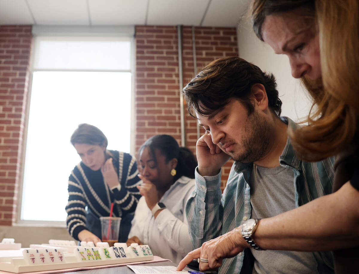 Mahjong instructor Jennifer Ross teaches Charlotte Observer reporter Jeff Chamer how to play as Lauren Ulrey, left, looks at reporter Briah Lumpkins' tiles Wednesday, Feb. 11, 2026 at the Charlotte Observer office in Charlotte.