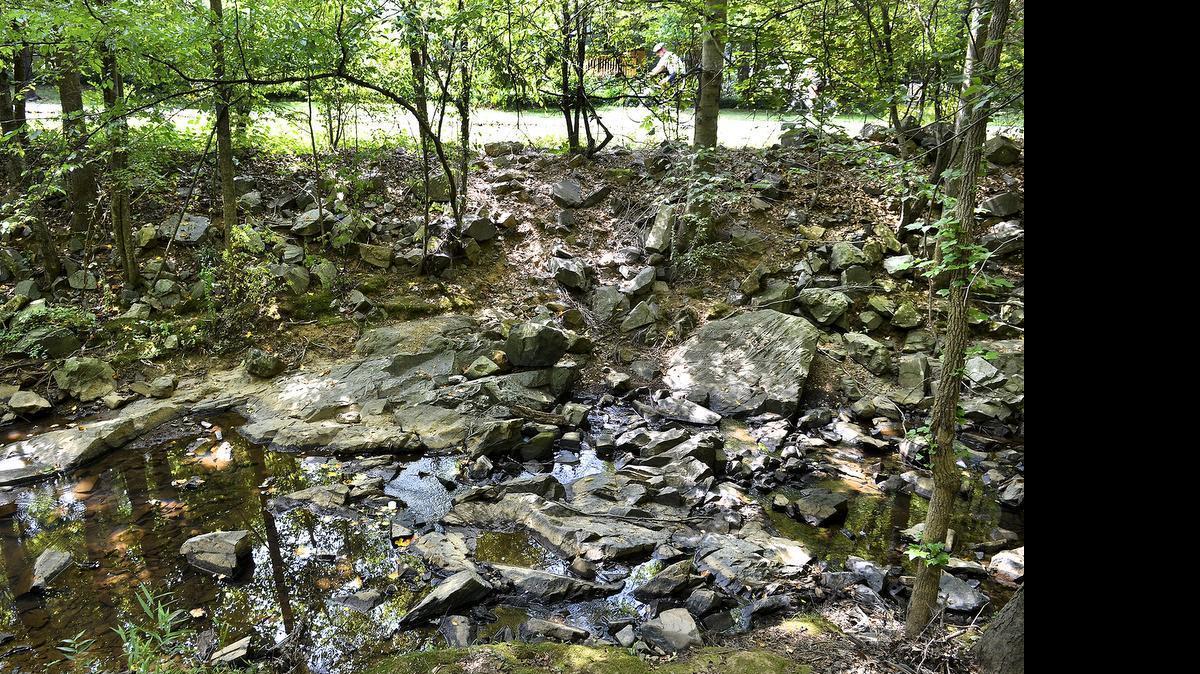 
Cyclists on Clark's Creek Greenway in northeast Charlotte ride by a nearly dry creek bed. Clark’s Creek’s flowing waters are usually about 12 inches deep. 
