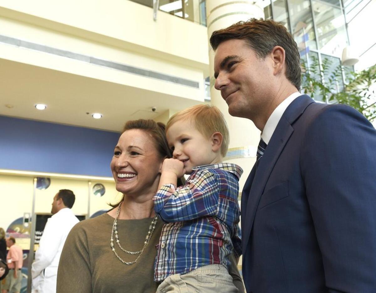 Kelly Weaver holds her son Andrew Weaver, 2 1/2 years old, a pediatric cancer survivor as they pose for a photo with Jeff Gordon.