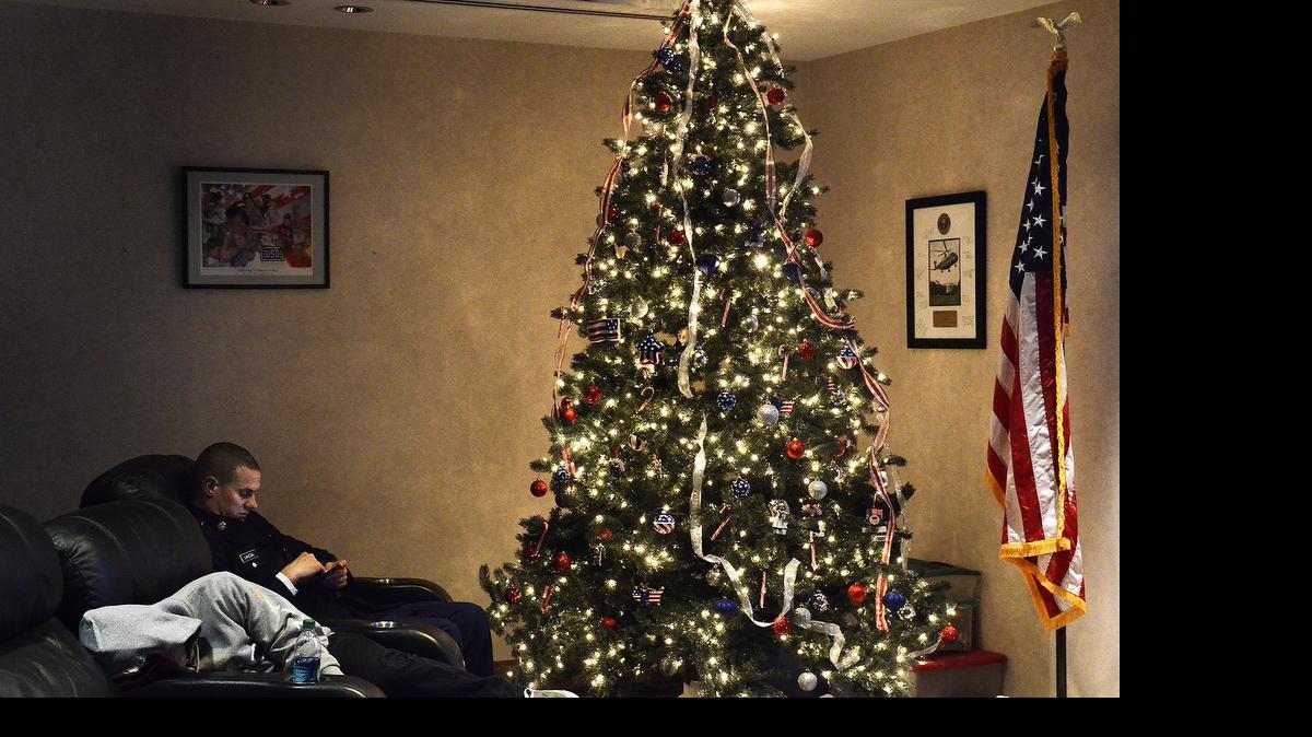
E4 Specialist Kevin Lancial checks his cell phone while sitting in the USO lounge next to the Christmas tree Saturday morning. About 4,000 soldiers in basic training at Fort Jackson will come through Charlotte Douglas International Airport in the annual Operation Victory Block Leave, also called Operation Exodus, event. Volunteers from the USO Charlotte Center and other groups will greet the soldiers, give them directions to gates or to the second-floor balcony where they can get a free breakfast or relax before headed home for a two-week leave. They began arriving at the airport around 3:30am on Saturday December 20, 2014.
