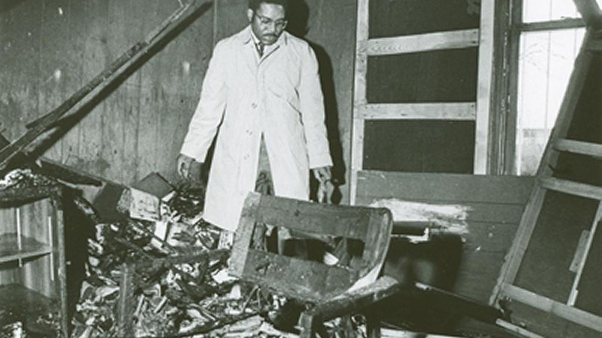 Julius Chambers searches through his firebombed office in Charlotte in February, 1971. His Charlotte home and car also were firebombed in 1965.