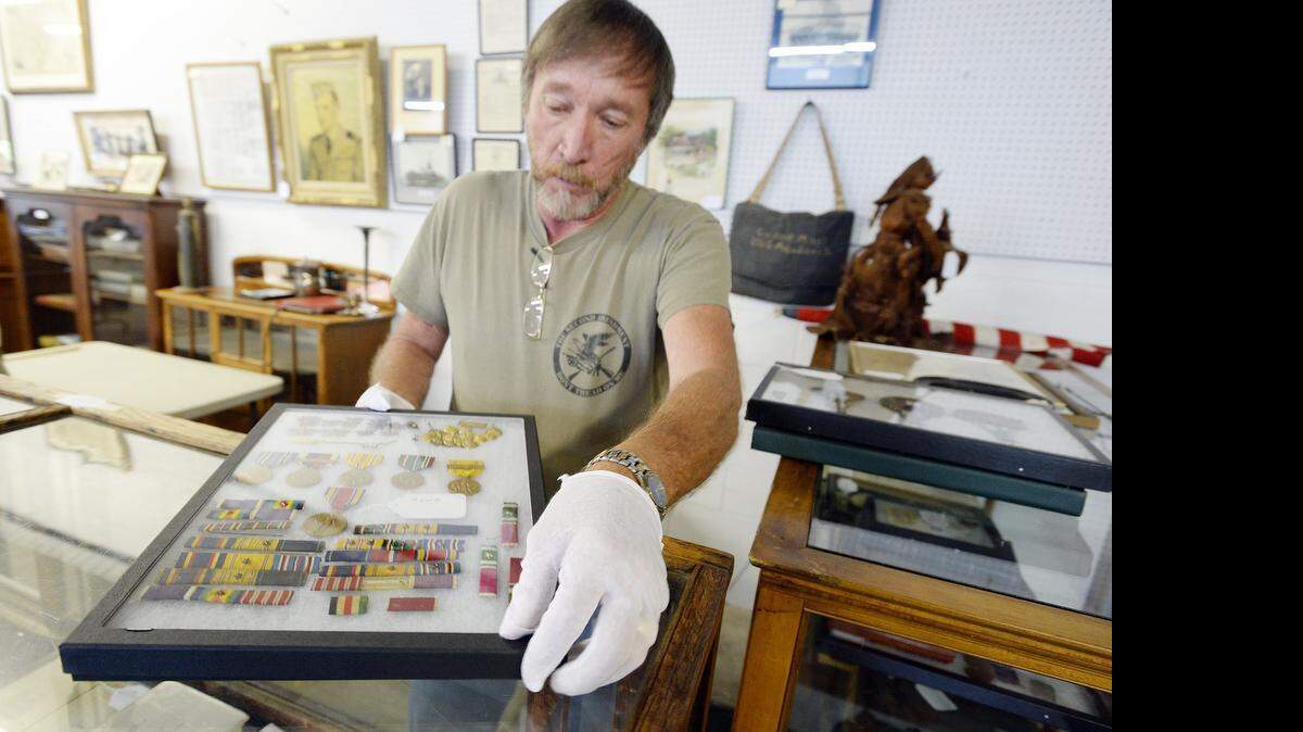 
Lewis Alexander, chairman of Iredell Historic Properties Commission displays military service ribbons and metal of Admiral Charles Lee Andrew Jr. 
