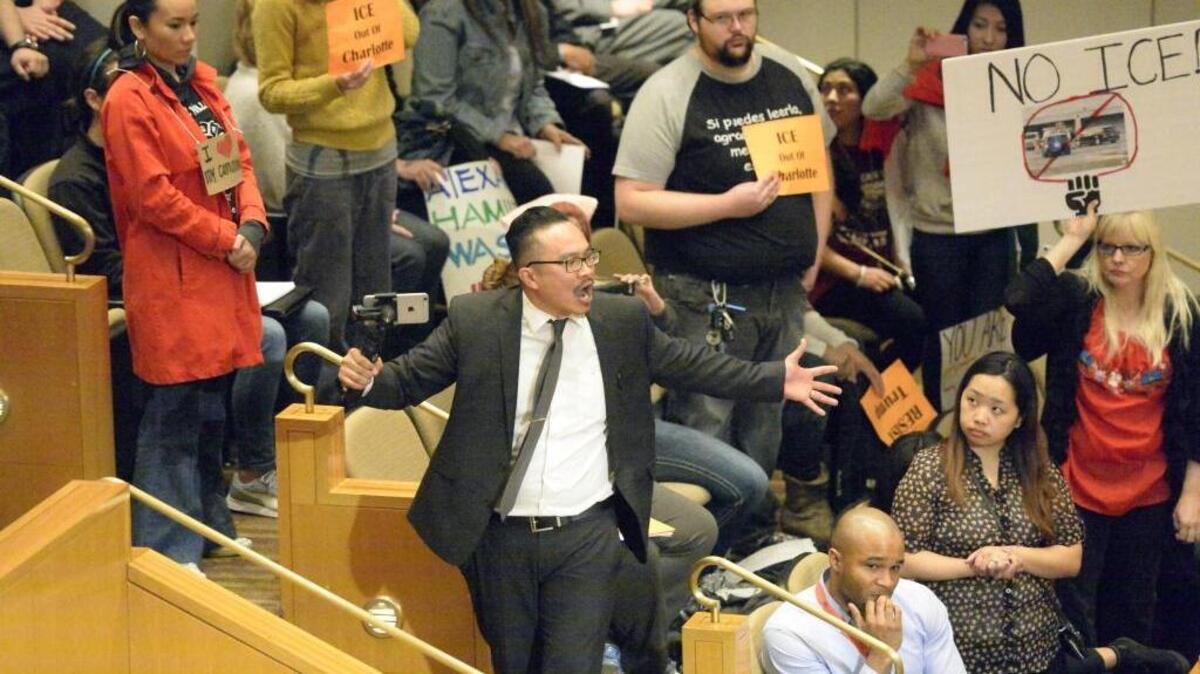 An audience member yells toward the Charlotte City Council during an immigration protest at the Charlotte City Council meeting on Monday, February 27, 2017. The audience member was later escorted out of the meeting.