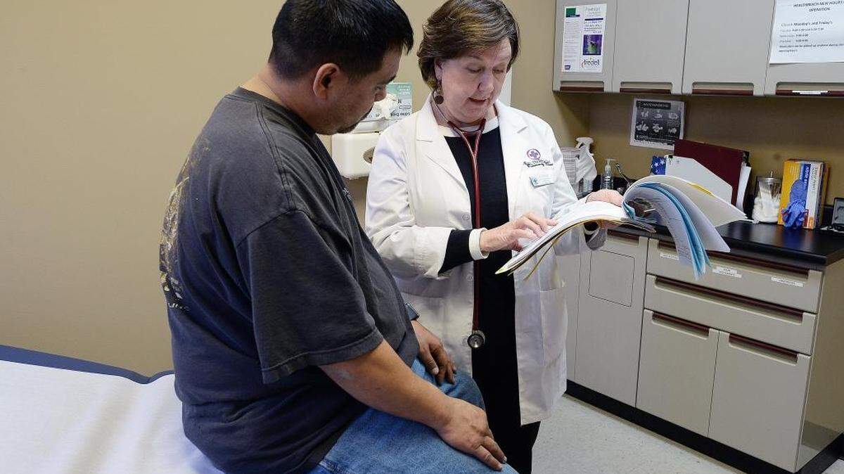Family nurse practitioner, Anne Potter, reviews patient Alex Ming’s medical chart during his examination. HealthReach Community Clinic, a free health care clinic in Mooresville, has cut its days of operation from five to three and accepted the resignation of its director to save money after a 70 percent decline in donations.
