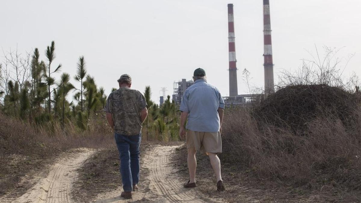 Sam Malpass (left) and Kenneth Sandlin walk in their small community near Duke Energy’s Sutton power plant in Wilmington.