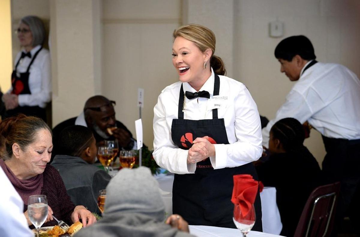 Volunteer server Stacy Hertel greets people at one of her tables at the Charlotte Rescue Mission.