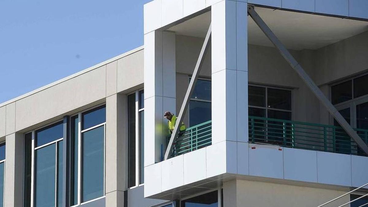 An OSHA official looks over the railing on the fifth floor of a building under construction where a worker died Sunday morning Oct.18, 2015, after he fell from a construction site on Camden Road in Charlotte's South End.