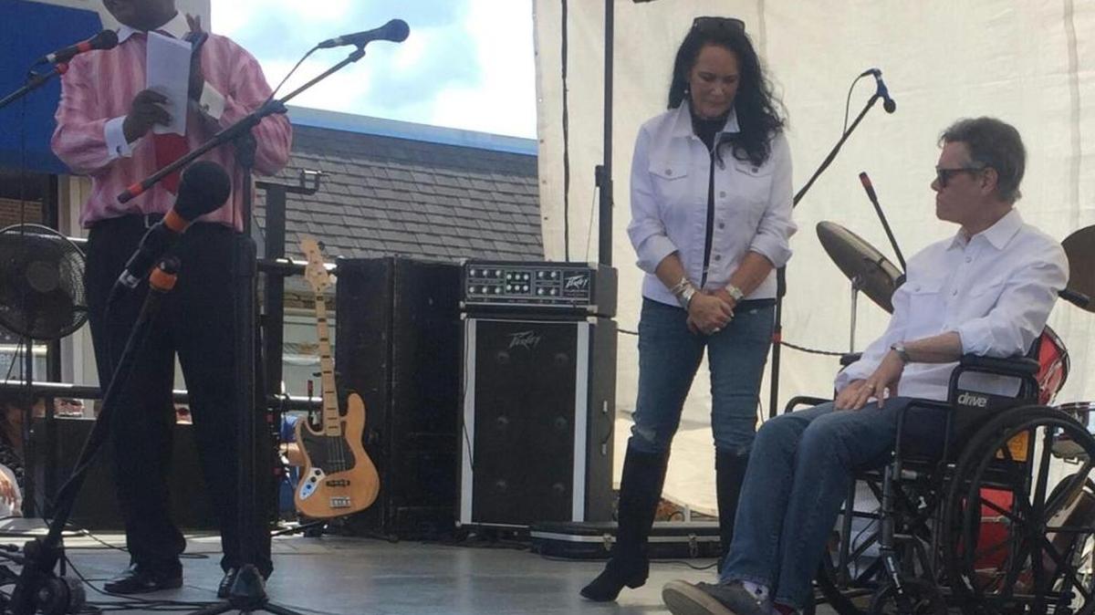 Marshville Mayor Franklin Deese (left) makes a presentation to Randy Travis and his wife, Mary Travis, in Marshville on Saturday.