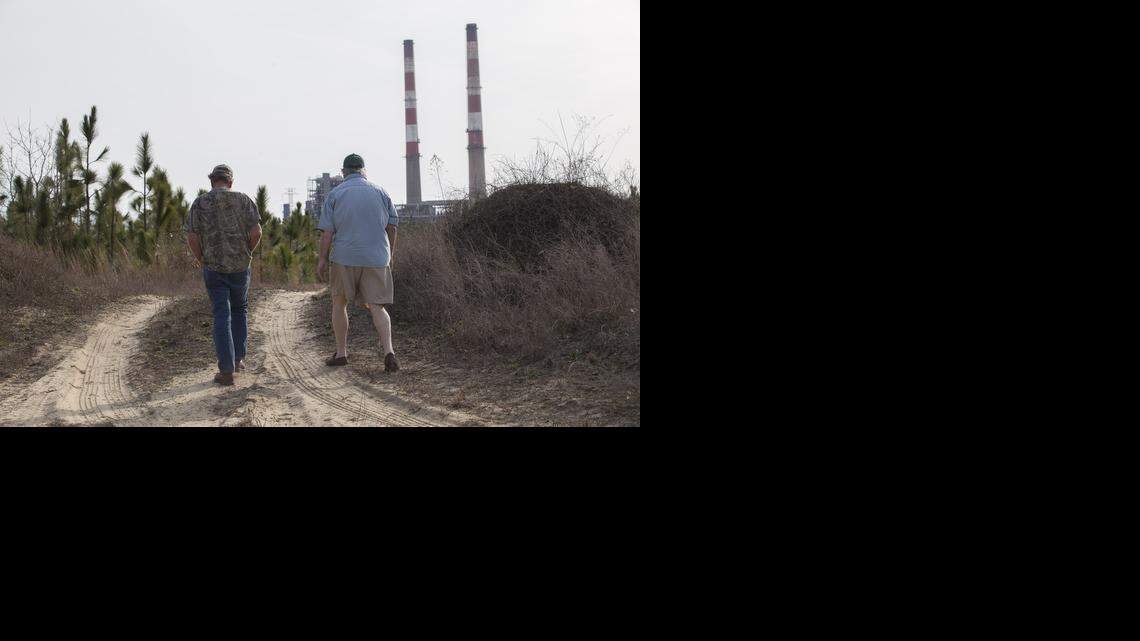 
Flemington Road community neighbors Sam Malpass, left, and Kenneth Sandlin of Wilmington walk through former hunting grounds near their homes on Feb. 19. The two are part of a small community near the L.V. Sutton Complex operated by Duke Energy. Contaminated groundwater from Sutton is moving toward its community wells.
