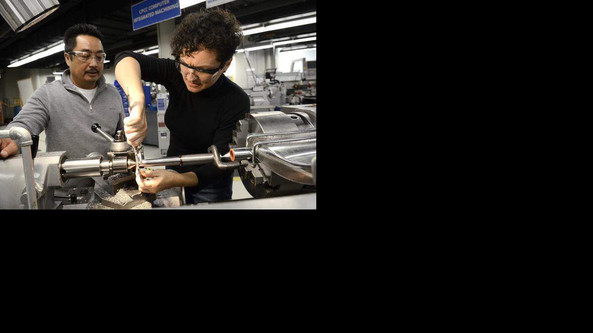 
Jonathan Phomsouvanh, left, and Agata Kedzierska machine from raw steel a “tapered center” in the CPCC Computer Integrated Machining Center on Feb. 12. 
