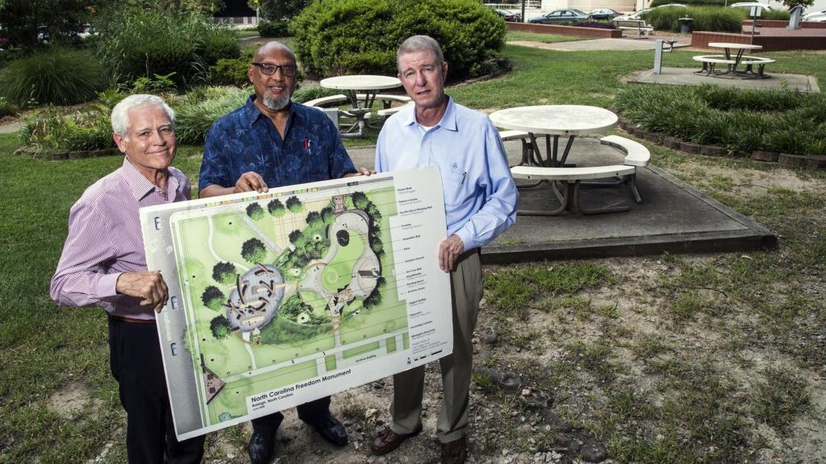 
Representatives from the North Carolina Freedom Monument Park from left, David Warren, Reginald Hodges and Kel Landis pose with an artist rendering of park plans Thursday, August 6, 2015 at the intersection of East Lane and North Wilmington Streets in downtown Raleigh. 
