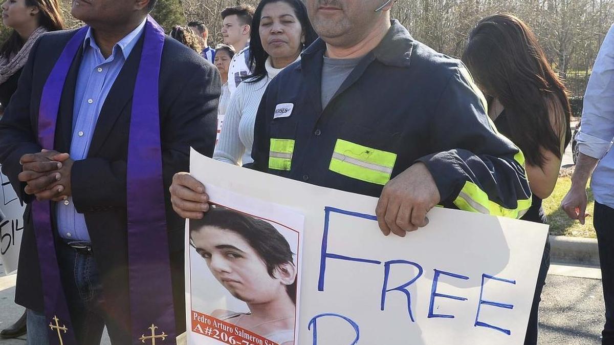 Moises Salmeron holds a picture of his nephew, Pedro Arturo Salmeron, then 18, during a prayer protest at the Department of Homeland Security in February. His nephew has now been deported.