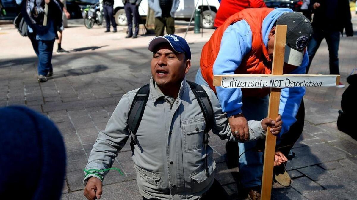 Protestor Bacilio Castro, center, participates in a mock arrest of immigrants at Trade and Tryon Streets in Charlotte earlier this year. Local activists acted out the dramatization of an immigration raid, in order to educate the community on the realities of families who face immigration raids.