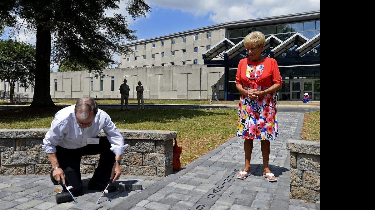 
Hamp Hager, left, with the Garinger Education Foundation prepares to place a paver for Glenn Cook as Cook's sister Jan Bradley, right, watches on Saturday, May 30, 2015 at Garinger High School in Charlotte, NC. Cook grew up on Arnold Drive in Charlotte, NC graduated from Garinger High and the Citadel before joining the Air Force. In 1969 his plane was shot down over South Vietnam. Cook's remains have never been returned and his parents died believing he'd one day come home. He never had a memorial service.
