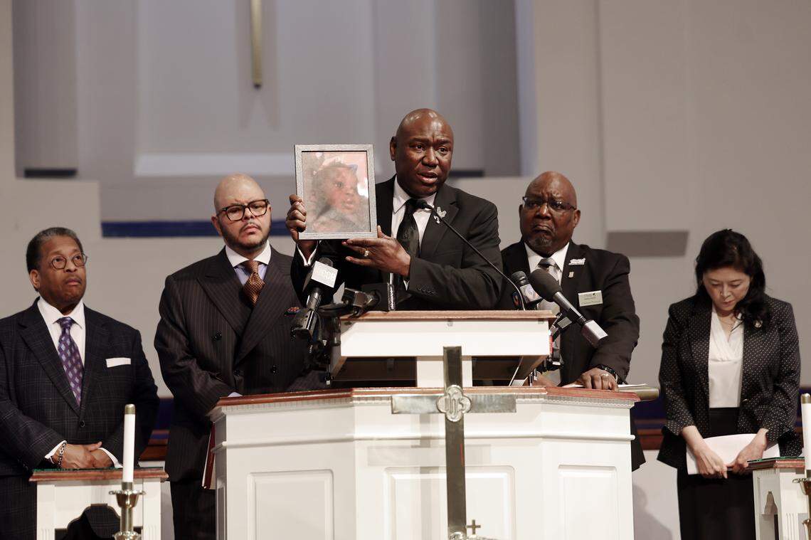 Attorney Ben Crump, center, holds a photo of Dominique Moody, who died at age 6 of prolonged injuries while in the custody of an aunt. The family, lawyers, and a pastor surround him on Monday. The group held a press conference detailing their investigation into the child's death last December.