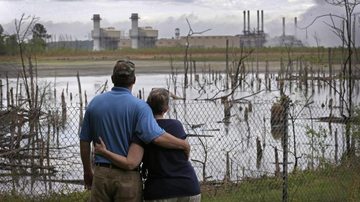 Bryant and Sherry Gobble look from their yard across an ash pond toward Duke Energy's Buck power plant near Salisbury.