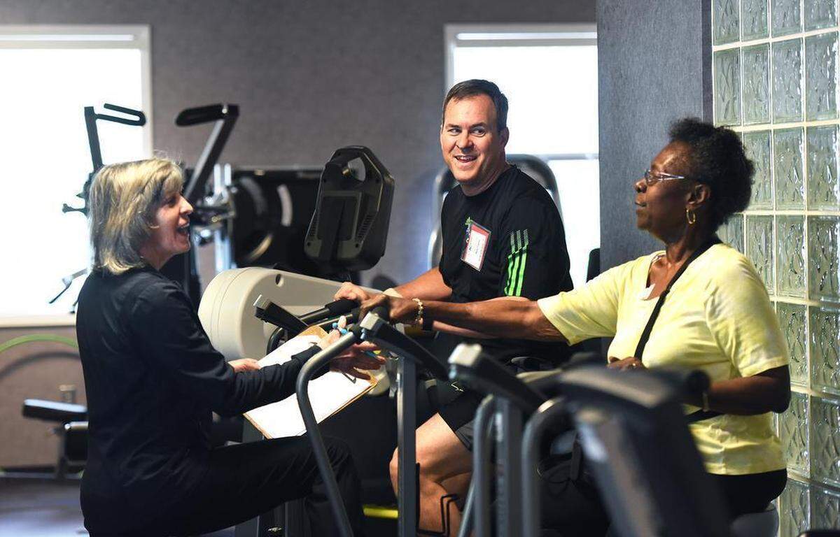Elaine Barnes and Nathan Taylor share a laugh with Vera Kindred at Novant Health’s cardiac rehabilitation center in Elizabeth, not far from where Taylor collapsed this past March.