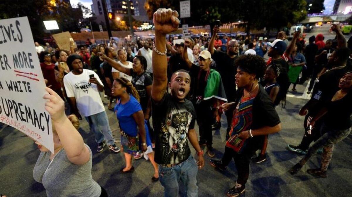 Protestors block an intersection near the Transit Center as they march uptown in Charlotte, NC on Wednesday, September 21, 2016. The protestors were marching and rallying against CMPD officer Brentley Vinson's fatal shooting of Keith Lamont Scott on Tuesday evening at The Village at College Downs apartment complex in the University City area.