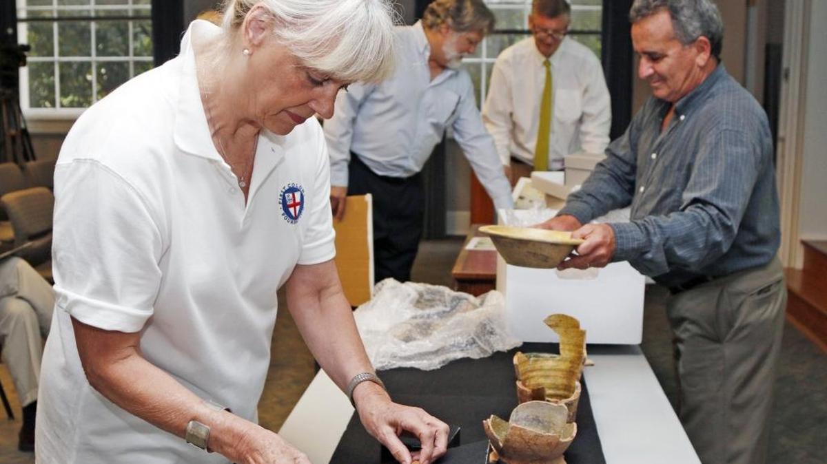 First Colony Foundation curator Bly Straube compares pottery shards found at Site X to other 16th-century pottery in this 2015 photo. The Coastal Land Trust said Wednesday it has acquired the 1,000-acre site in Bertie County and plans to transfer it to state ownership.