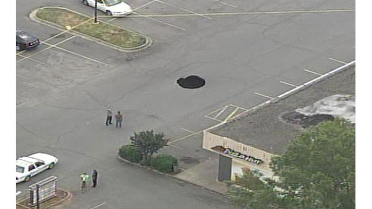Officers were called to assist firefighters after a sinkhole opened up in the parking lot of Pizza Hut on the 9600 block of Monroe Road, between Sardis Road North and Orchard Lake Drive on May 13.