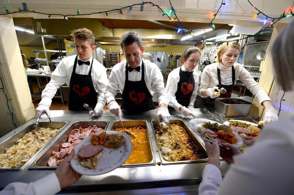 Volunteer servers fill plates with turkey, ham, sweet potatoes, dressing, green beans and cranberry sauce at the Charlotte Rescue Mission on Monday. The Charlotte Rescue Mission will serve over 1,000 meals on Christmas to anyone in need of a special holiday outing.