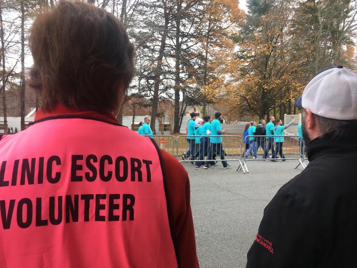 Volunteers at A Preferred Women’s Health try to direct women toward the clinic amid a large pro-life prayer walk.
