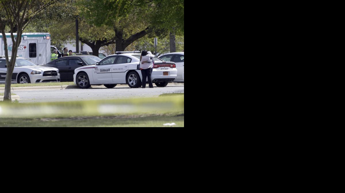 
Two people hug as students and faculty wait outside Wayne Community College during a lockdown following a shooting on campus in Goldsboro. One person was killed in the shooting. 
