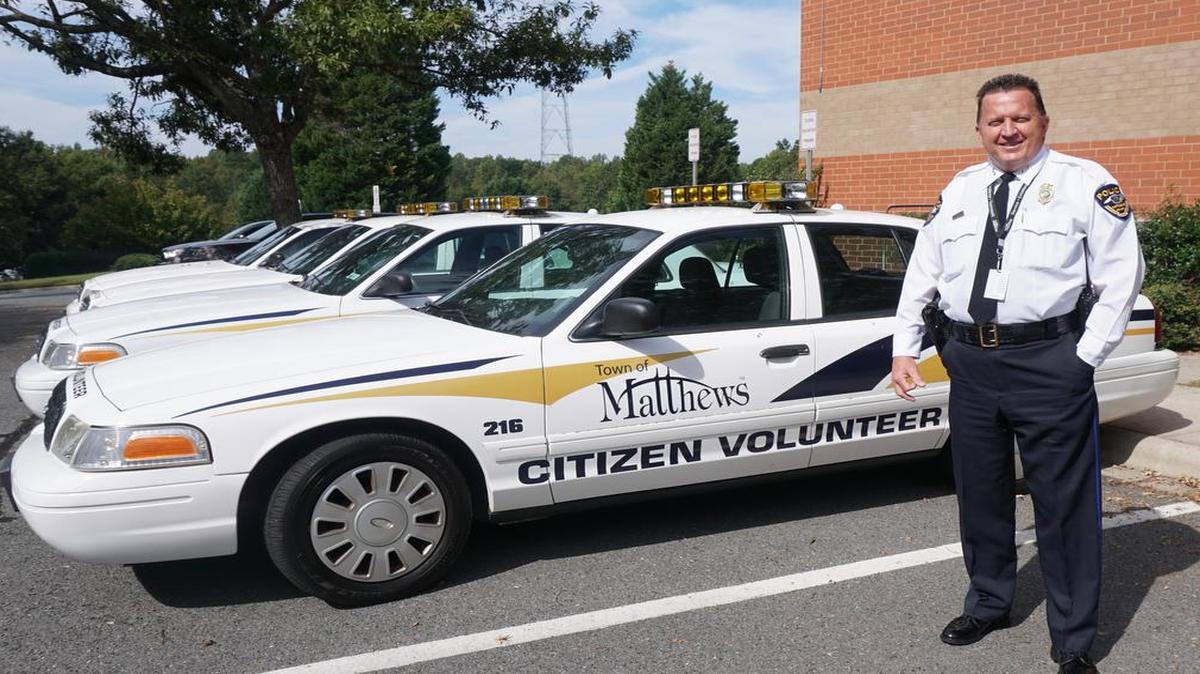 Matthews Police Chief Rob Hunter stands beside a Matthews Citizen Volunteer car, one of the initiatives he’s overseen in his 24 years as chief. He is retired Oct. 1.