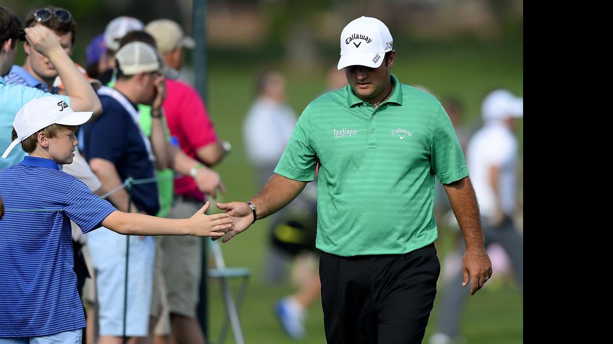 
A young fan, left, reaches out to slap hands with Patrick Reed, right, as he walks to the 17th green during first round action of the Wells Fargo Championship at Quail Hollow Club in Charlotte,Thursday. The tournament and several other events over the weekend could also call traffic headaches in the Charlotte area. 
