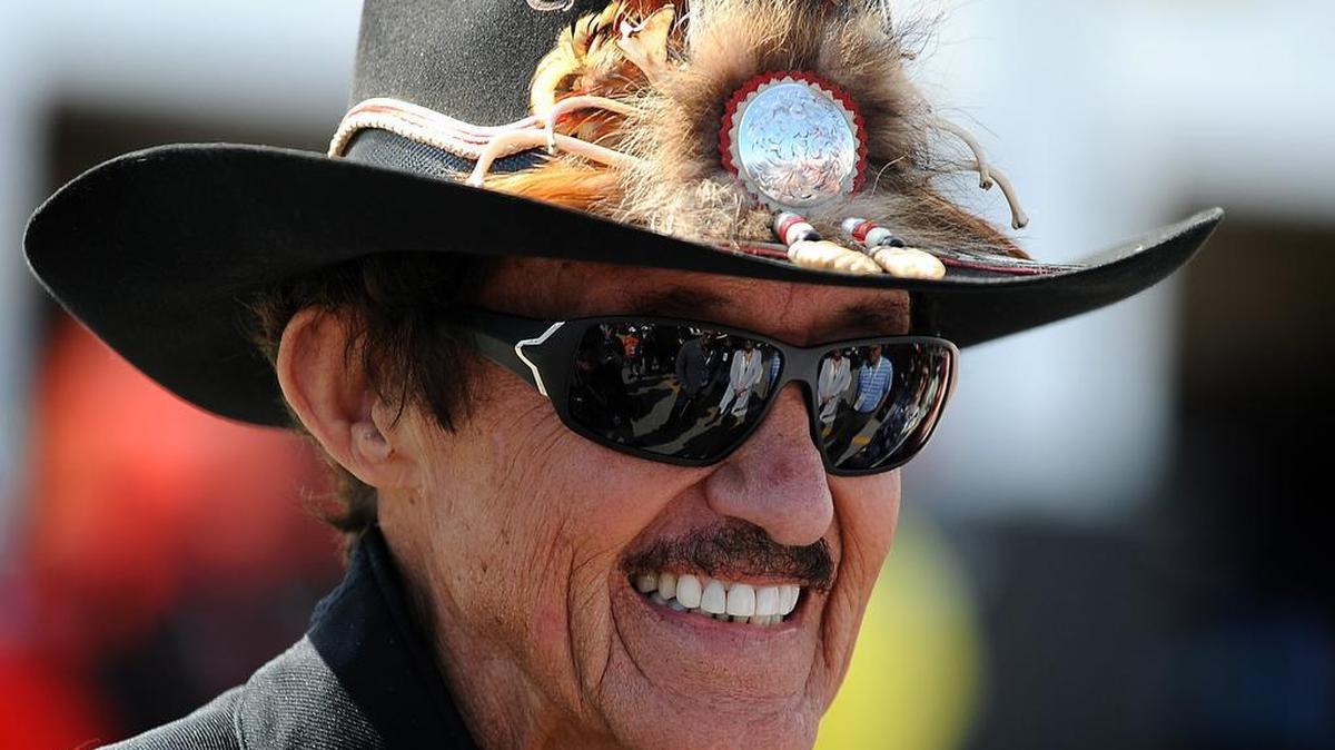 Seven-time NASCAR champion Richard Petty stops and talks with fans in the garage area at Daytona International Speedway on Feb. 19, 2016.